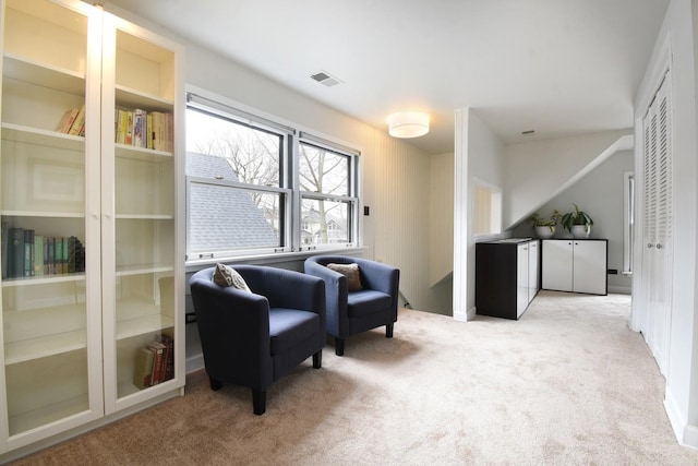 living area featuring light carpet and visible vents