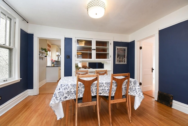 dining area featuring light wood-style floors and baseboards