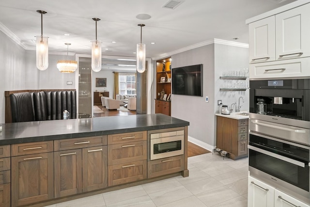 kitchen with stainless steel oven, crown molding, a sink, oven, and a warming drawer