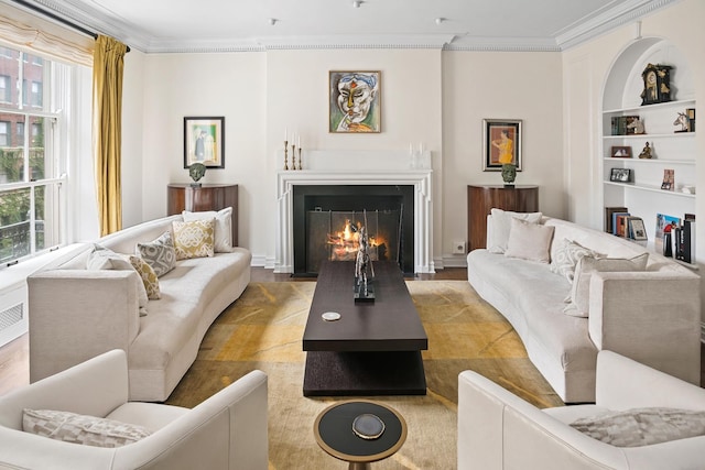 living room with ornamental molding, plenty of natural light, built in shelves, and a warm lit fireplace