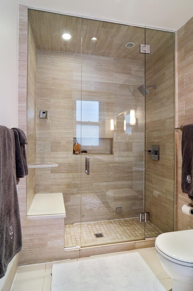 bathroom featuring toilet and a stall shower