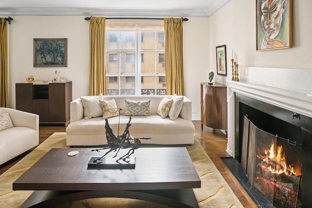 living area featuring a fireplace with flush hearth, crown molding, and wood finished floors