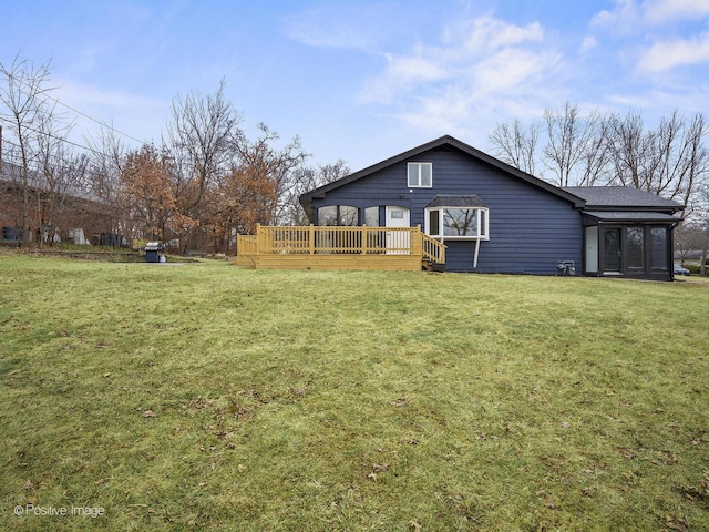 rear view of house with a lawn and a wooden deck