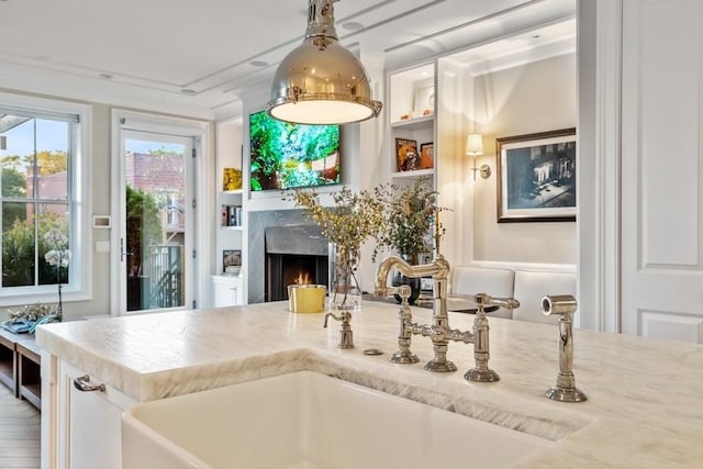 kitchen with sink, a fireplace, and built in shelves