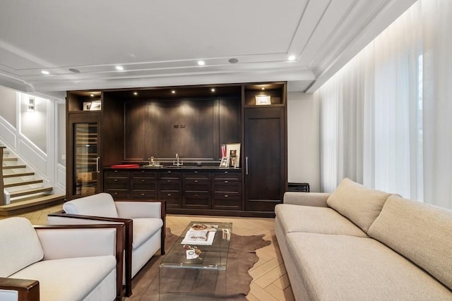 living room with ornamental molding and wet bar