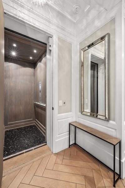 bathroom with crown molding, parquet flooring, and elevator