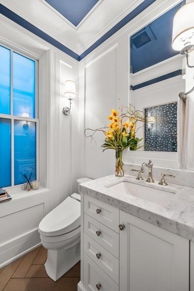 bathroom with vanity, crown molding, and toilet