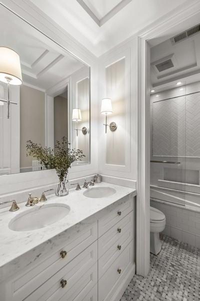 bathroom featuring vanity, a tray ceiling, and toilet