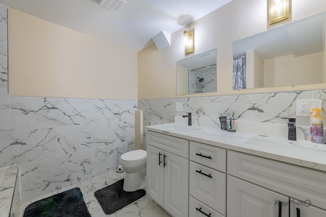 bathroom with tile walls, toilet, vanity, and curtained shower