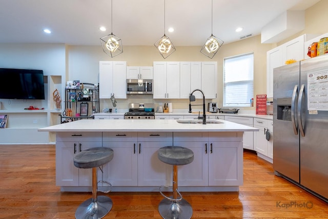 kitchen featuring white cabinetry, an island with sink, appliances with stainless steel finishes, and sink