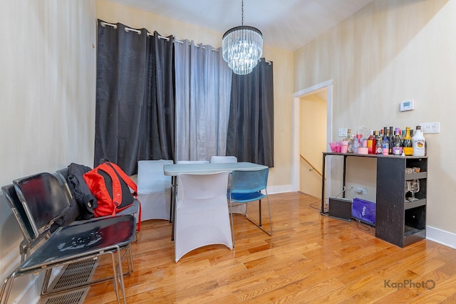 dining area featuring light wood-type flooring and an inviting chandelier