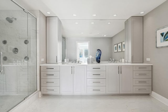 full bath featuring double vanity, marble finish floor, a sink, and a stall shower