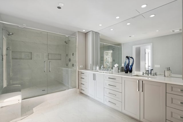 bathroom with double vanity, a stall shower, a sink, and recessed lighting