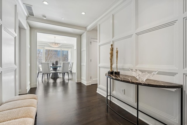 interior space featuring crown molding, dark wood finished floors, recessed lighting, visible vents, and a decorative wall