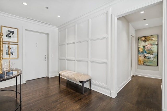 corridor with recessed lighting, dark wood finished floors, crown molding, and a decorative wall