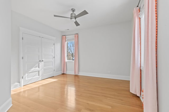 unfurnished bedroom with a ceiling fan, baseboards, and light wood finished floors