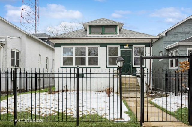 view of front of property featuring a shingled roof, a fenced front yard, and stucco siding