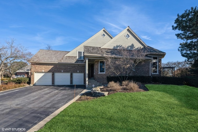 view of front of property with a front yard, an attached garage, brick siding, and driveway