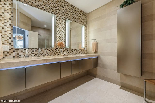 bathroom featuring double vanity, a stall shower, a sink, tile patterned flooring, and tasteful backsplash