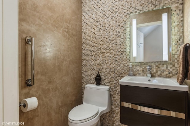 bathroom featuring decorative backsplash, tile walls, toilet, and vanity