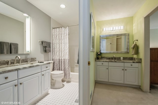 full bathroom featuring shower / bath combo with shower curtain, toilet, two vanities, and a sink