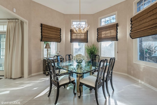 dining space with baseboards and an inviting chandelier