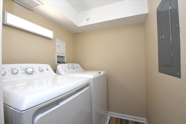 laundry room with electric panel, washer and dryer, and dark hardwood / wood-style flooring