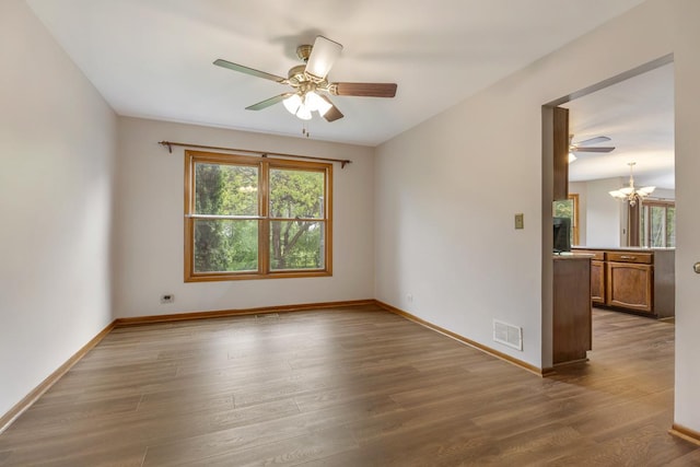 1185 Surrey Ln, Itasca, IL 60143 - spare room with a chandelier, a ceiling fan, wood finished floors, and baseboards