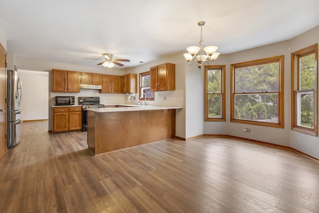 1185 Surrey Ln, Itasca, IL 60143 - kitchen with gas stove, freestanding refrigerator, under cabinet range hood, a peninsula, and dark wood finished floors