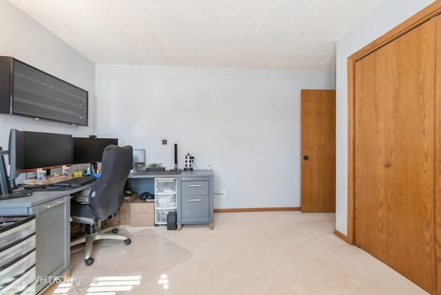 office area featuring light carpet and baseboards