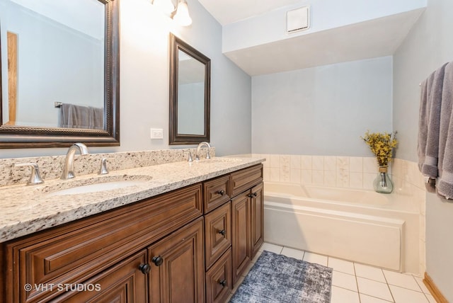 bathroom with double vanity, tile patterned flooring, a sink, and a bath