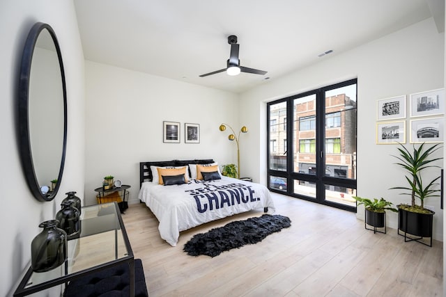 bedroom with access to exterior, visible vents, light wood-style floors, and ceiling fan