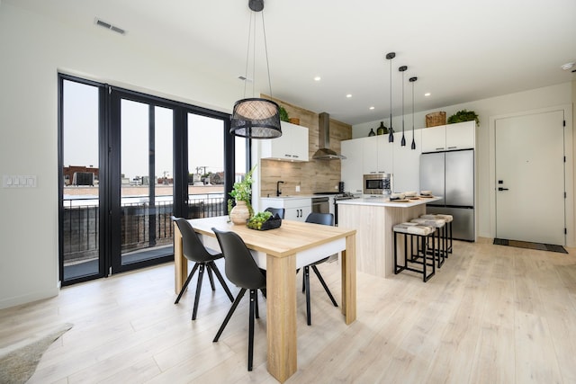 dining area featuring light wood-type flooring, visible vents, and recessed lighting