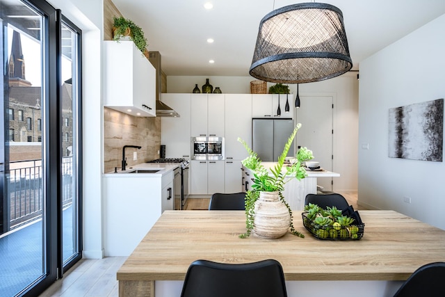 dining space with light wood-type flooring and recessed lighting