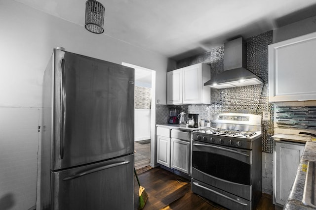 kitchen with wall chimney range hood, refrigerator, white cabinetry, backsplash, and stainless steel range with gas cooktop