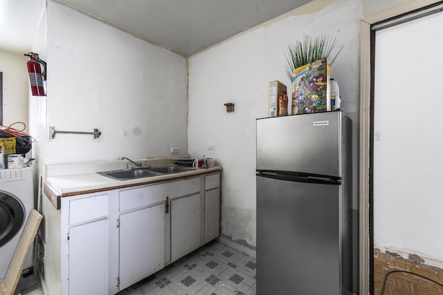 kitchen featuring sink, washer / dryer, and stainless steel fridge