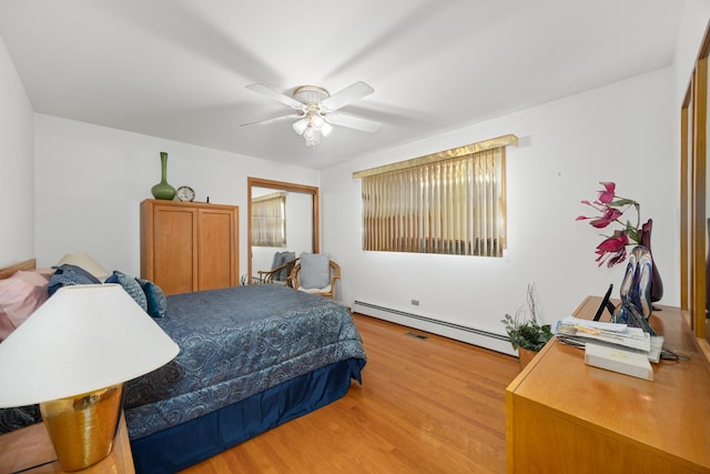 bedroom with light wood-style flooring, baseboard heating, and a ceiling fan