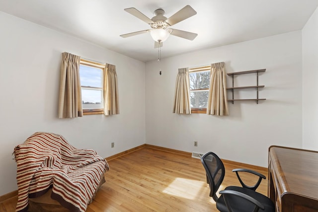 office with light hardwood / wood-style floors and ceiling fan