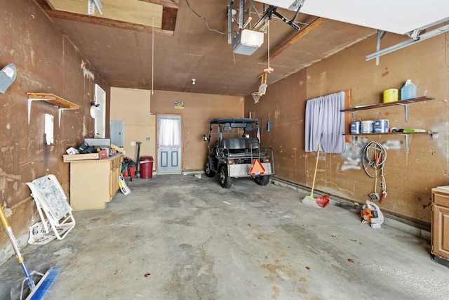 garage featuring a garage door opener, a workshop area, and electric panel