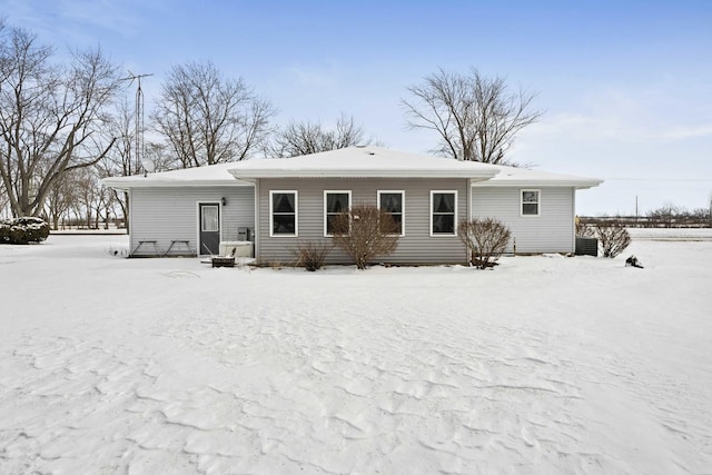 snow covered rear of property with central AC unit