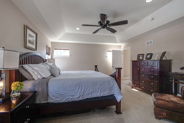 bedroom with recessed lighting, a raised ceiling, visible vents, and light carpet