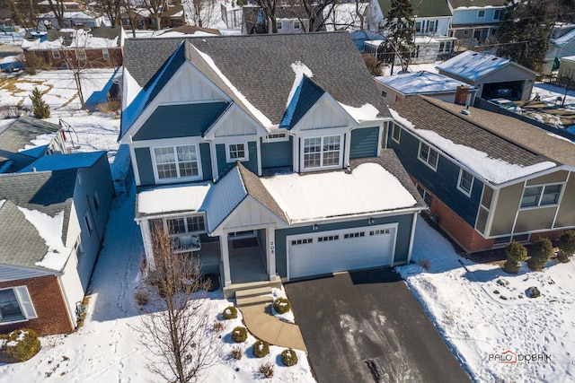 view of front of property with a garage, roof with shingles, board and batten siding, and driveway