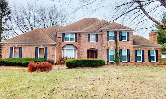 7N108 Hastings Dr, Saint Charles, IL 60175 - view of front of property with a chimney, a front lawn, brick siding, and a shingled roof