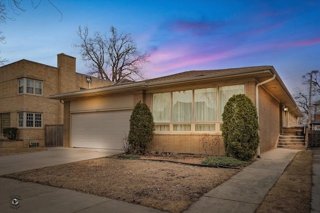 view of front facade featuring driveway, brick siding, and an attached garage