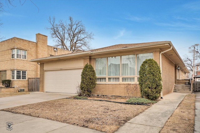 view of front of house with driveway, an attached garage, and brick siding