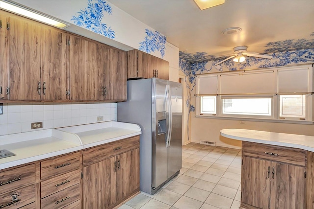 kitchen with light countertops, stainless steel refrigerator with ice dispenser, and brown cabinets