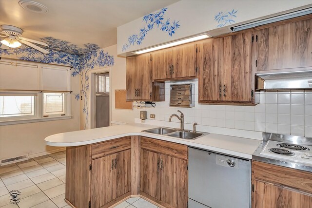 kitchen featuring a peninsula, a sink, visible vents, brown cabinets, and dishwasher