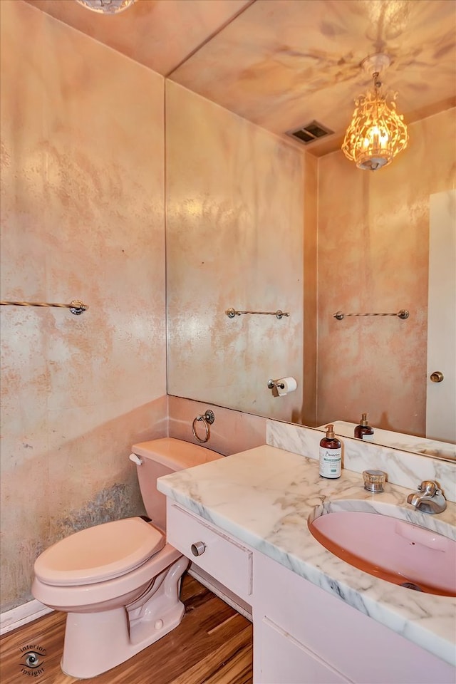 bathroom featuring visible vents, vanity, toilet, and wood finished floors