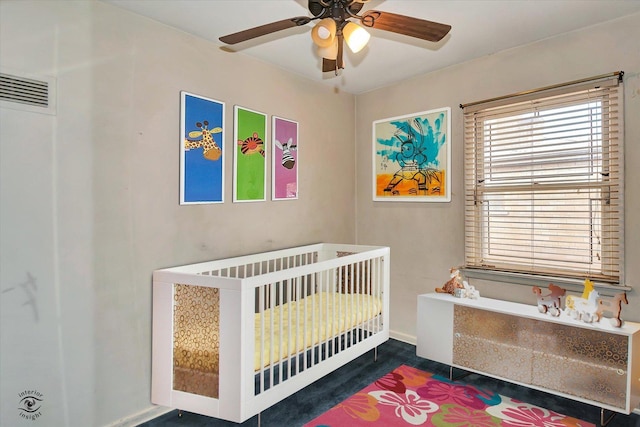 bedroom featuring a ceiling fan, a nursery area, and visible vents