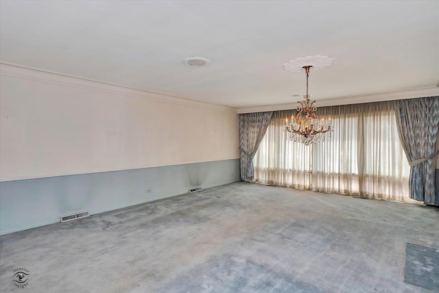 unfurnished room with an inviting chandelier, visible vents, and crown molding